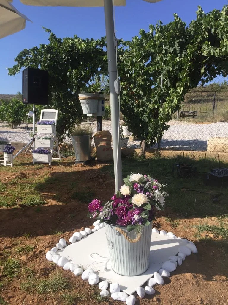 Centro floral en cubo de zinc entre las cepas del viñedo