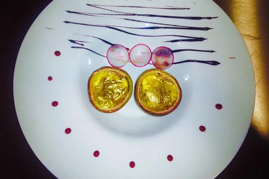 Postre emplatado con hilos de chocolate y crema