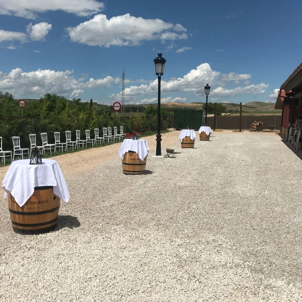 Sillas blancas y barriles de madera en la terraza de la finca