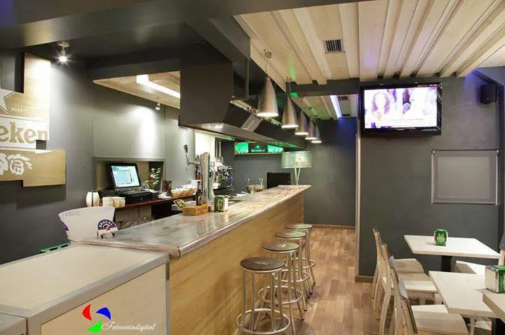 Barra de La Mantequería con taburetes y pantalla de televisión