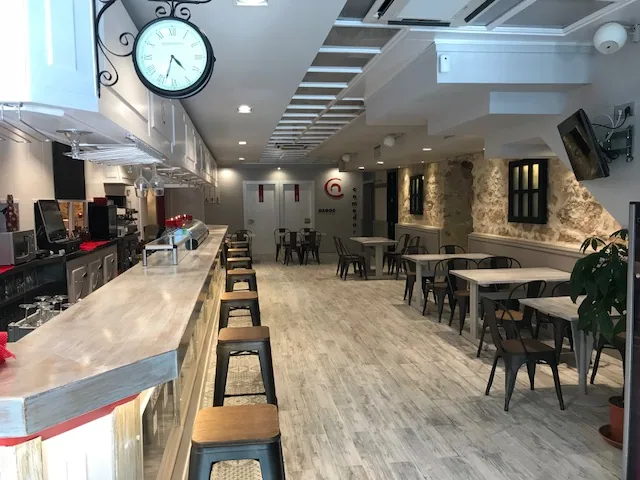 Barra de la cafetería Capitol con taburetes y el reloj de pared