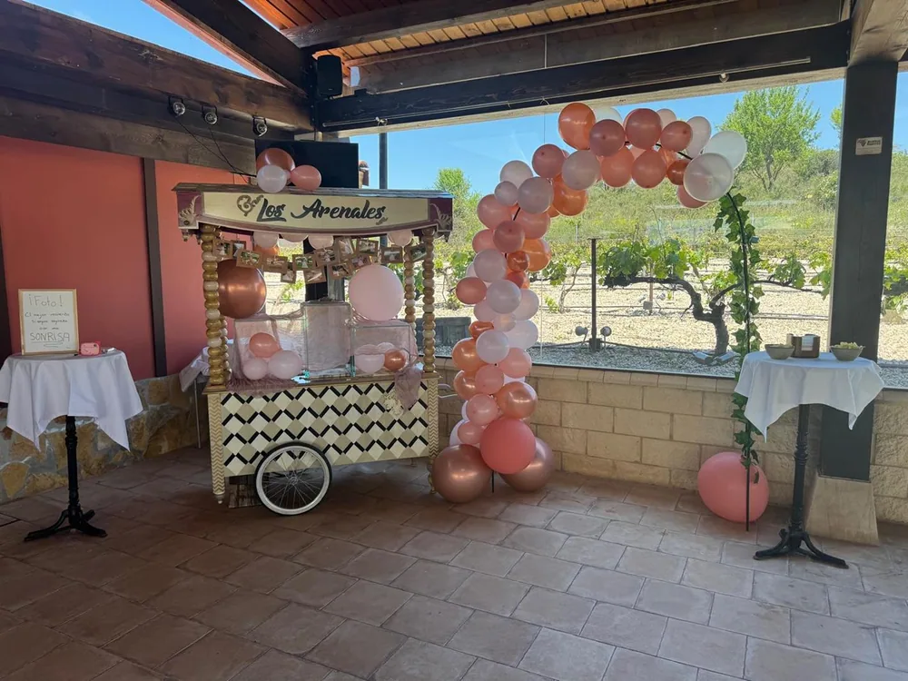 Carrito de dulces de Los Arenales decorado con un arco de globos en tonos rosas
