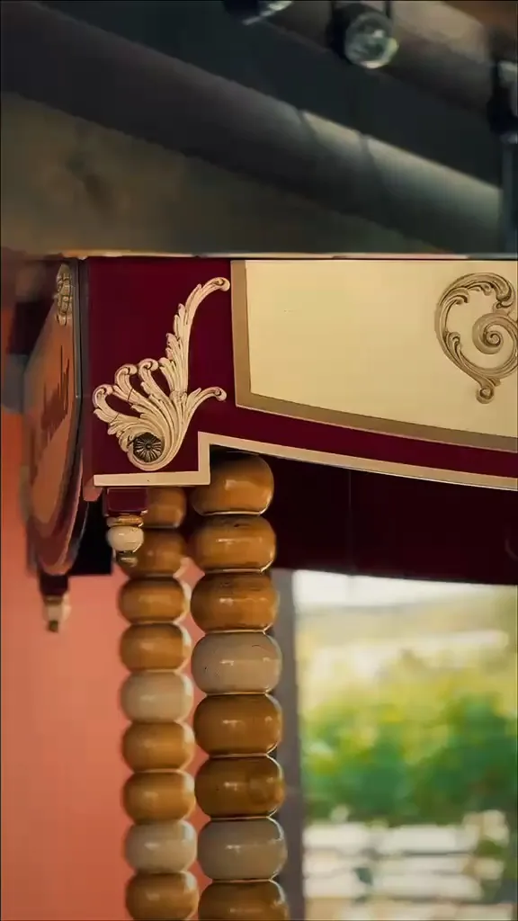 Detalle del carrito vintage de Los Arenales, con terciopelo granate y molduras doradas